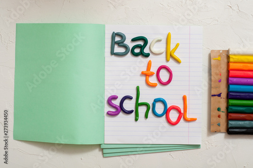 School supplies and inscription back to school on color background photo