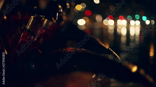 Rainy night in Barcelona. Beautiful lights and abstract background from the water reflections on the wet pavement. Cars and bikes riding on the background. Dark composition and colourful details