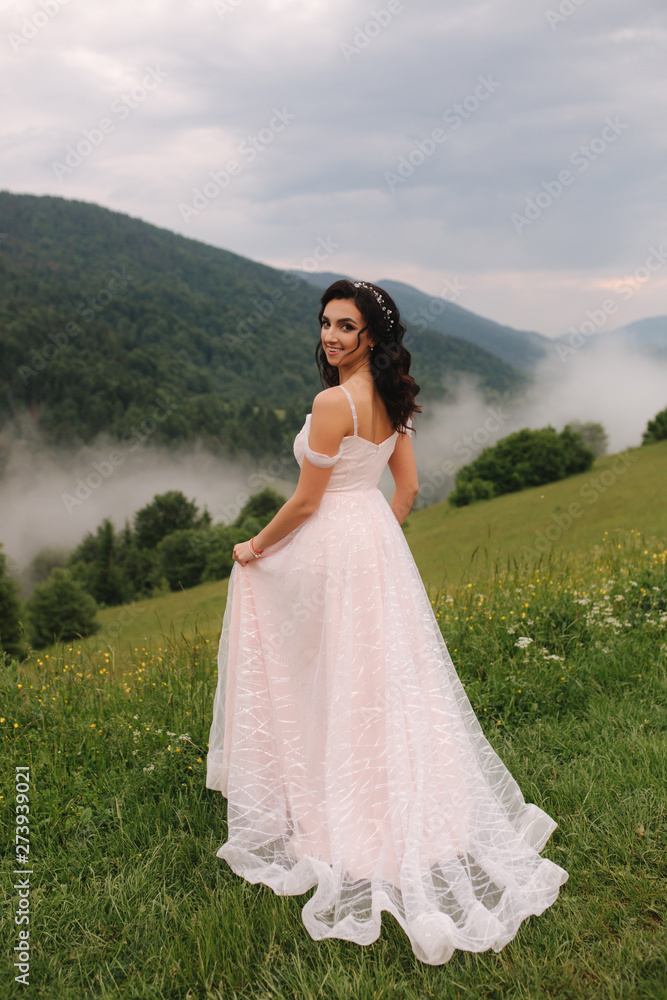 Charming bride in beautiful Carpathian mountais. Elegant woman in beautiful dress