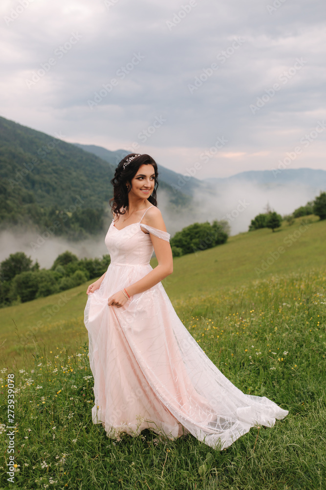 Charming bride in beautiful Carpathian mountais. Elegant woman in beautiful dress