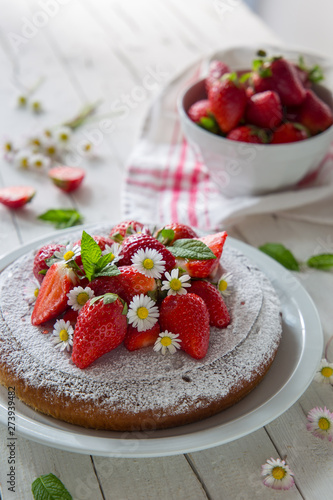 Torta con fragole decorata con margherite e menta