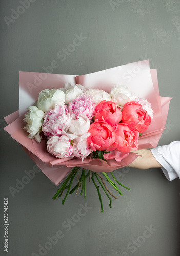 lush bouquet of flowers of peonies r hands, pink and white flowers
