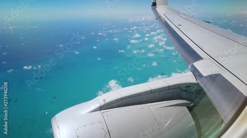 wing and engine of an airplane flying over bahamas