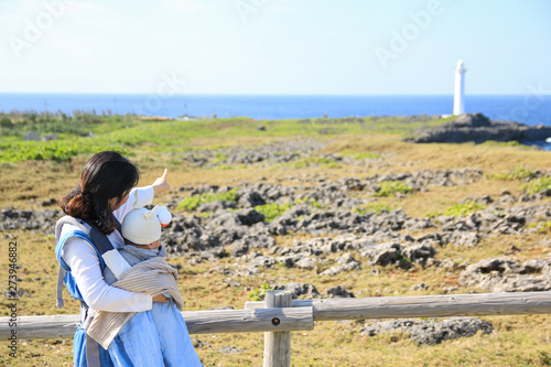 Asian mother and he baby on family trip in Zanpa seaside park in Okinawa photo