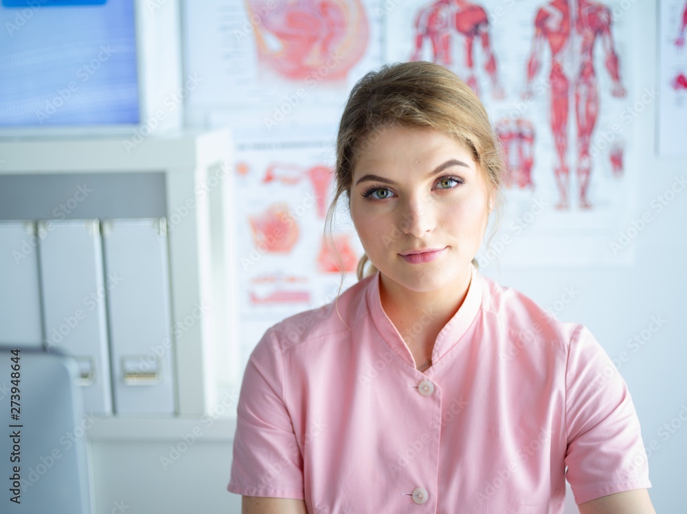 Portrait of young female doctor sitting at desk in hospital Portrait of young female doctor sitting at desk in hospital