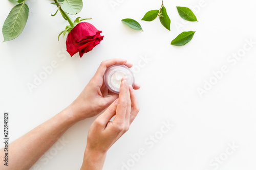 Natural organic cosmetics with rose extrac and hands on white background top view copyspace photo