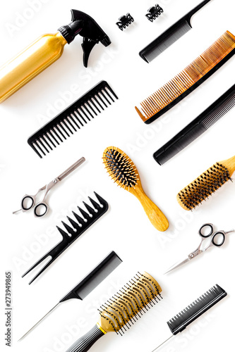 Combs, sciccors and hairdresser tools in beauty salon work desk on white background top view pattern
