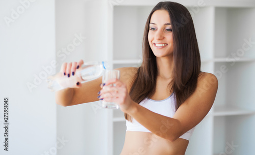 Beautiful smiling woman drink glass water in the morning