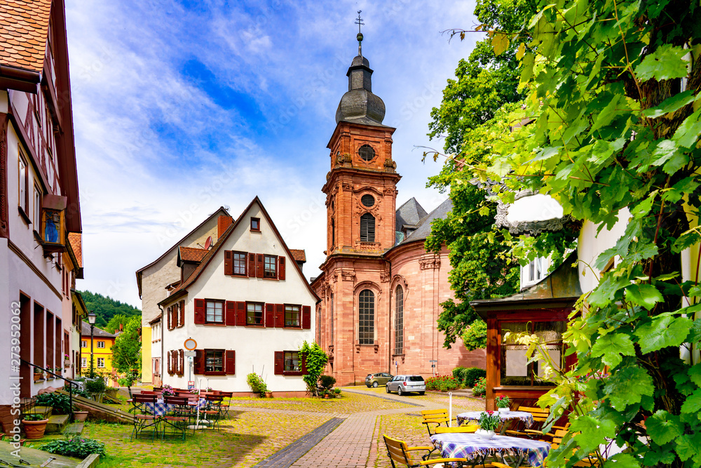 Naklejka premium Narrow street with view of the church in the old town of Amorbach in Lower Franconia, Bavaria, Germany