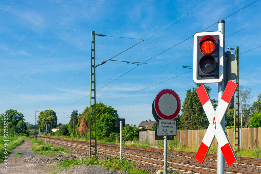 Outdoor Sunny View Of Small Suburb Street Railway And Red Traffic Light In Front Of Level Crossing Railway Barrier At Intersection Between Road And Railway In Small Village Meerbusch Germany Stock Photo
