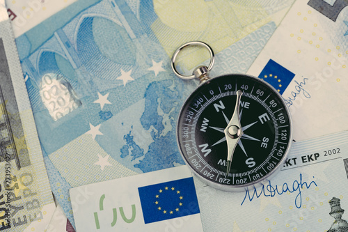 Direction of Europe and UK after brexit negotiation concept, compass on Euro banknotes with Euro flag and map of Europe and United Kingdom island photo