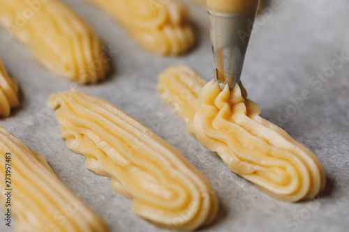 raw eclairs choux pastry on the baking tray photo