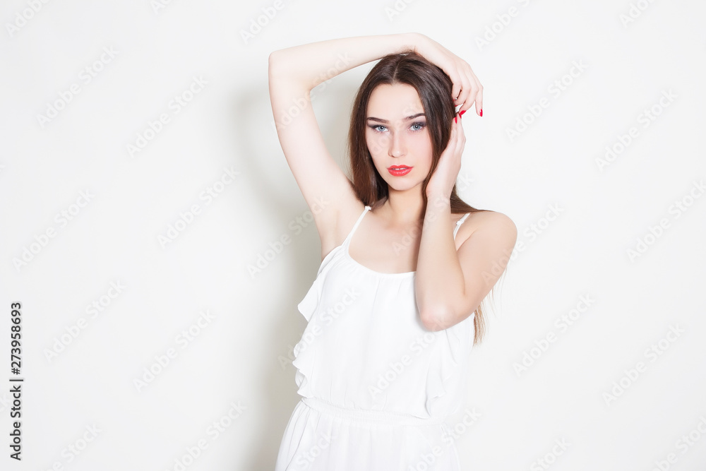 woman in white dress holds hands around her head