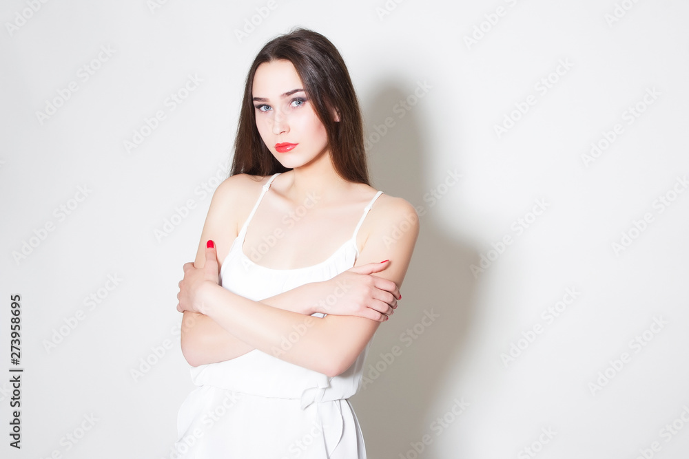woman in white dress holds hands around herself woman in white dress holds hands around herself