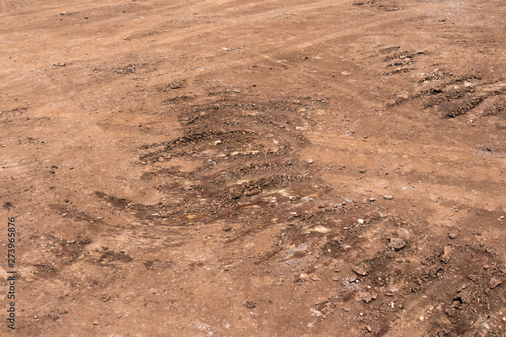 Cascading circle-shaped scratches left by construction vehicles as they pass through dirt roads Cascading circle-shaped scratches left by construction vehicles as they pass through dirt roads