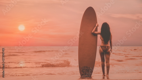 female happy playing wave board in sea during sunset