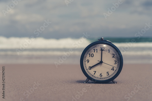 Selective focus of alarm clock with nature background.