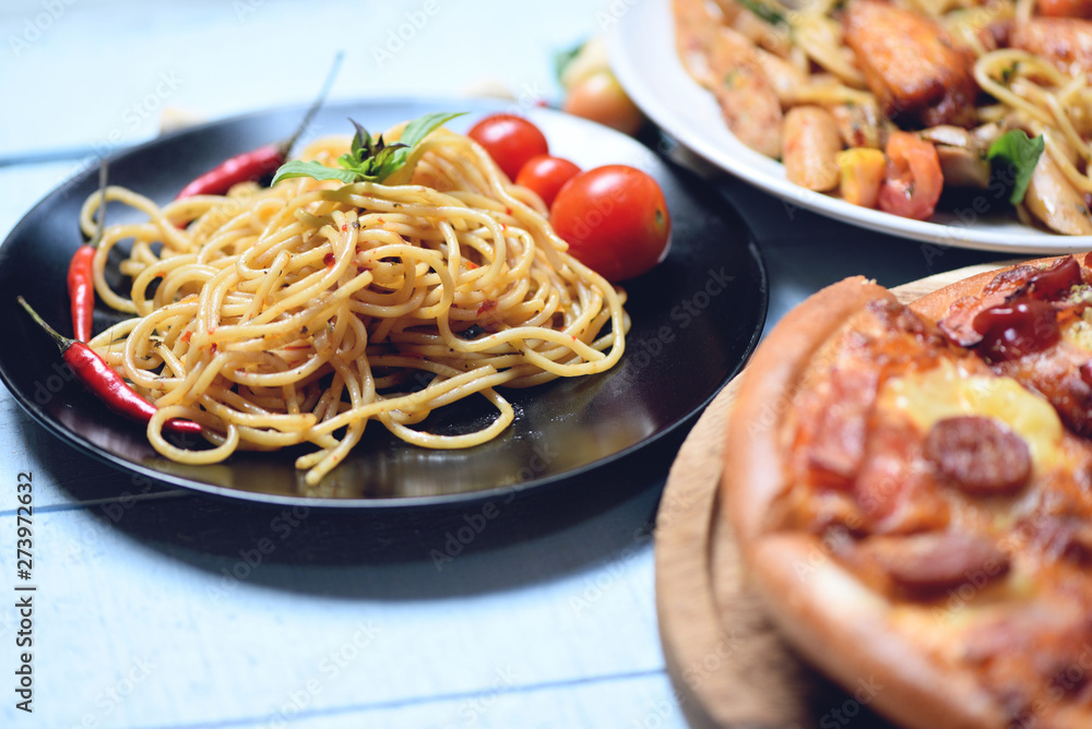 Fototapeta premium Spaghetti pasta and pizza on wooden tray - Traditional delicious Italian food spaghetti bolognese on plate on the dining table
