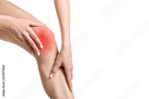 Female injured knee joint. Sore spot highlighted by red marker. Woman touches her leg. Well groomed skin  close up  isolated on white