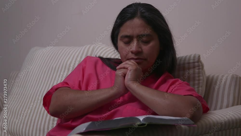 Christian Woman Reading Bible and Praying Wearing Scrubs Christian Woman Reading Bible and Praying Wearing Scrubs