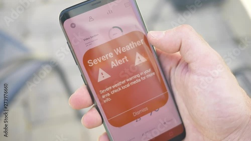 Receiving a SEVERE WEATHER warning notification on a smartphone screen. Blinking alert concept