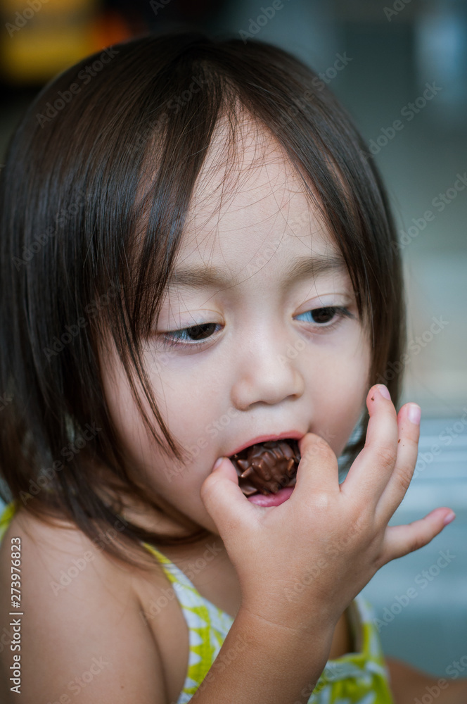 Portrait of asian little toddler girl with a full mouth of snacks. Portrait of asian little toddler girl with a full mouth of snacks.