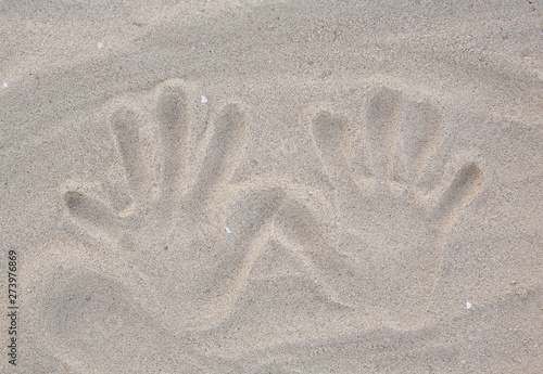 Obraz na plátně Hands stamp on the sand background.