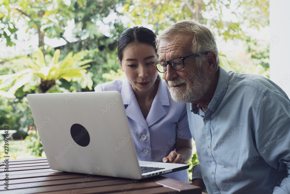 senior man happiness and nurse, using laptop at balcony near garden at nursing home for internet online together senior man happiness and nurse, using laptop at balcony near garden at nursing home for internet online together