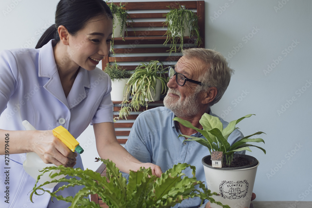 Obraz premium senior man happiness and nurse, take care of flower at balcony near garden at nursing home together
