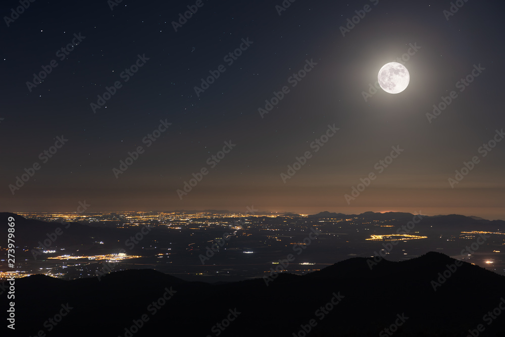 A beautiful full moon night in June in Spain with a view towards Cartagena. From the summit of Morron in the Sierra Espuna you have a beautiful view of the Mediterranean region.