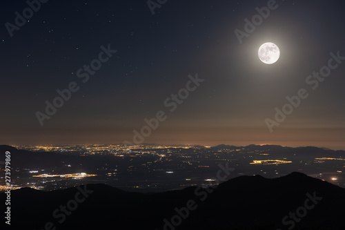 A beautiful full moon night in June in Spain with a view towards Cartagena. From the summit of Morron in the Sierra Espuna you have a beautiful view of the Mediterranean region. photo