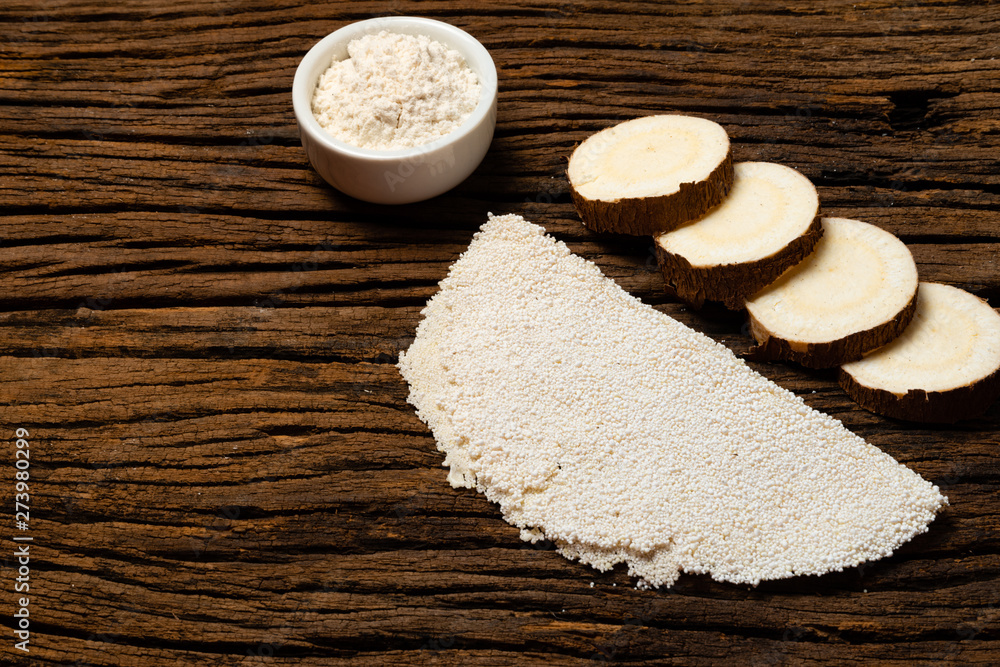 Beiju of tapioca, cassava-based dish typical of the northeastern region of Brazil, now consumed in the whole country on old wooden background. Beiju of tapioca, cassava-based dish typical of the northeastern region of Brazil, now consumed in the whole country on old wooden background.