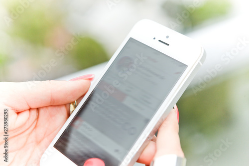 Wallpaper Mural Woman scrolling updates on her social media using her mobile phone. Torontodigital.ca