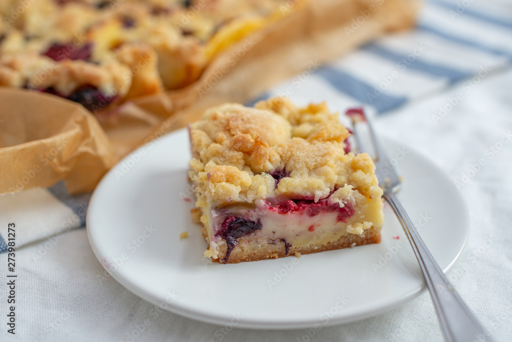 Sweet delicious crumble cake in a baking form and pieces of the cake on a table Sweet delicious crumble cake in a baking form and pieces of the cake on a table