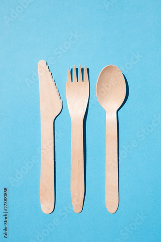 Wooden cutlery from above on a light blue background