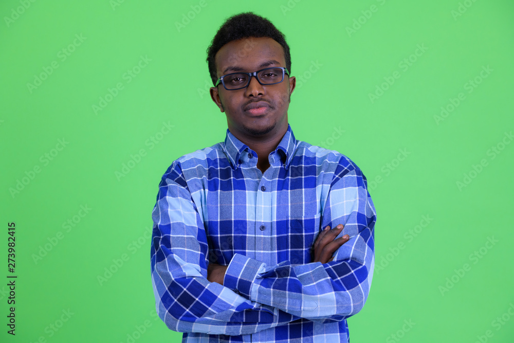 Young African hipster man wearing eyeglasses with arms crossed Young African hipster man wearing eyeglasses with arms crossed