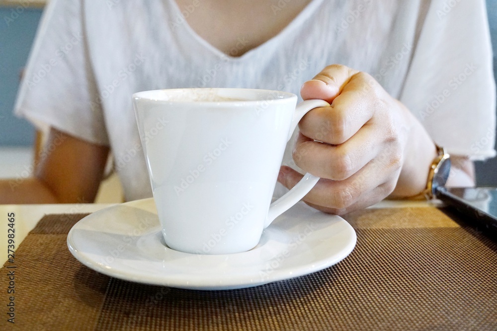 Selective focus of woman holding coffee cup on blurred background in the café, space for your text, in the morning