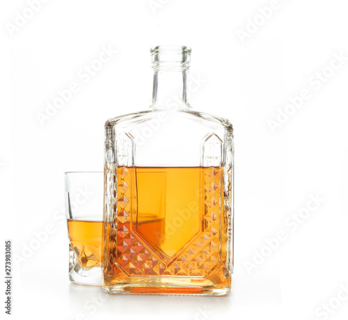 A crystal carafe and a glass of whiskey on a white background