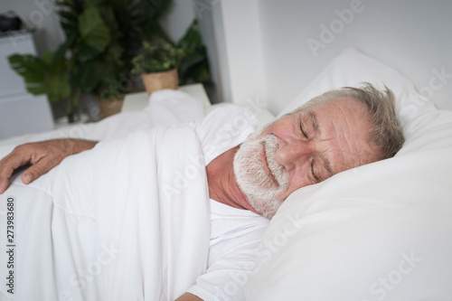 senior man sleeping alone and headache or dreaming nightmare on bed in room
