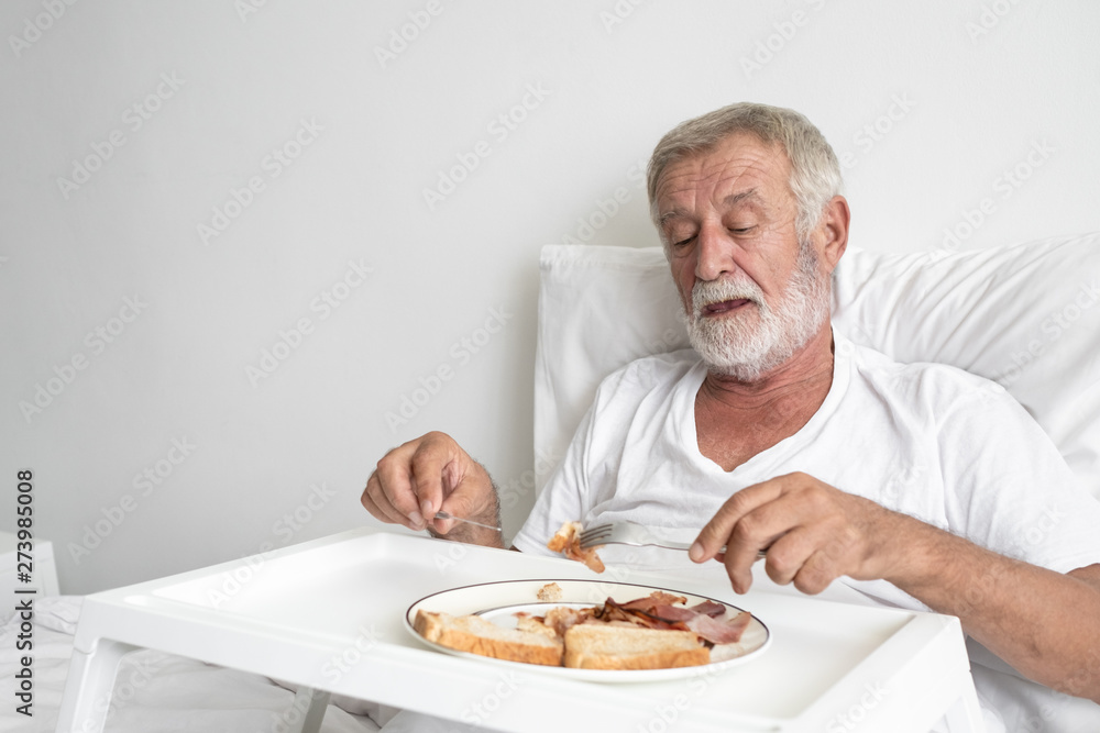 senior man with smiling nurse, takes care breakfast and discussion and cheer on bed at nursing home senior man with smiling nurse, takes care breakfast and discussion and cheer on bed at nursing home