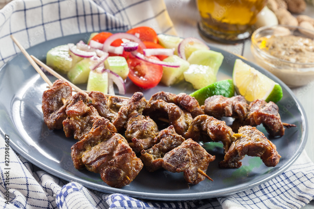 Traditional pork satay with peanut sauce and vegetables Traditional pork satay with peanut sauce and vegetables