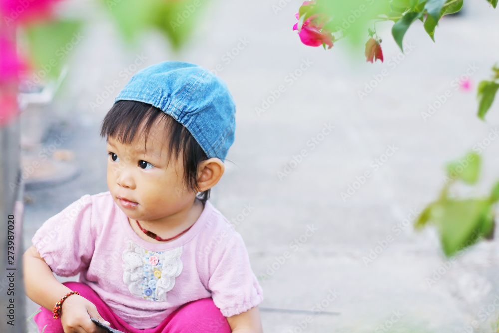 Soft focus, Asian baby child girl practice to walking at the garden. She playing with a toy and sitting at the ground. Development of baby aged of one year old. Soft focus, Asian baby child girl practice to walking at the garden. She playing with a toy and sitting at the ground. Development of baby aged of one year old.