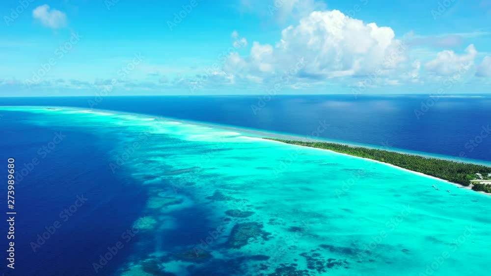 A thin with palm trees forested island in the turquoise Caribbean Sea. Shallow water in front of the island, the open ocean in the background. Slow dolly out with truck left, wide angle. A thin with palm trees forested island in the turquoise Caribbean Sea. Shallow water in front of the island, the open ocean in the background. Slow dolly out with truck left, wide angle.