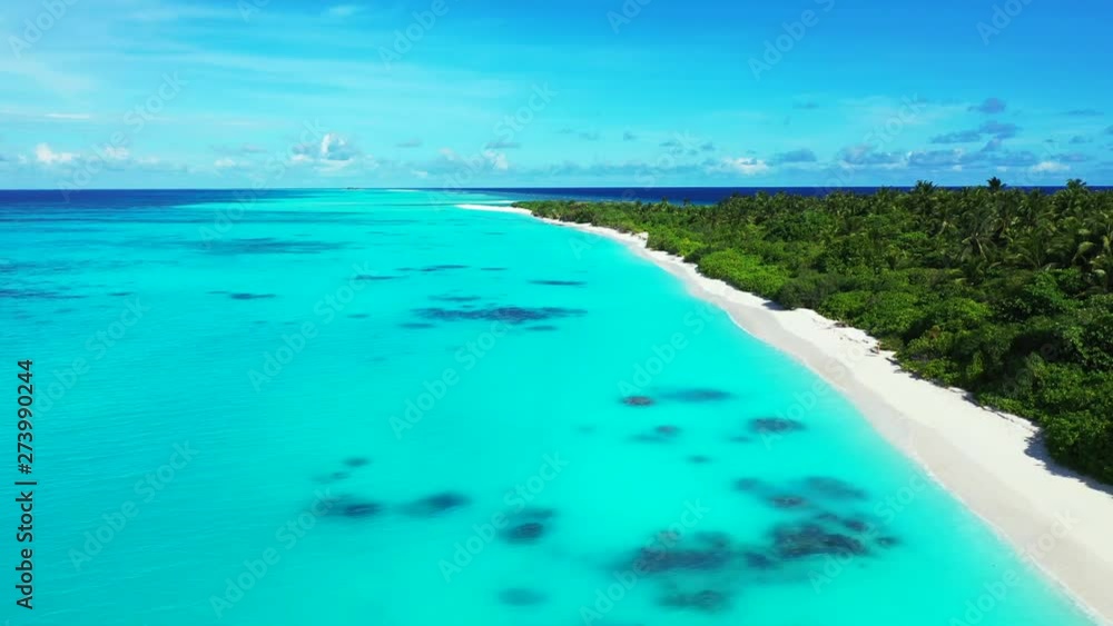 The soft turquoise Caribbean Sea with an island shore on the left. Aerial view pedestal up. The soft turquoise Caribbean Sea with an island shore on the left. Aerial view pedestal up.