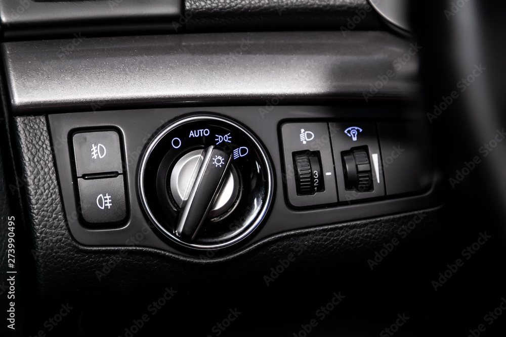 Close-up on the headlight switch control buttons, automatic adjust level dashboard. modern car interior: parts, buttons, knobs.. Close-up on the headlight switch control buttons, automatic adjust level dashboard. modern car interior: parts, buttons, knobs..