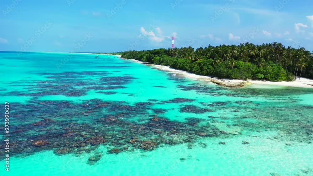 Flying away from an island in the turquoise Caribbean Sea with some rocks and reefs in the water. Palms trees an a radio mast on the island. Dolly out. Flying away from an island in the turquoise Caribbean Sea with some rocks and reefs in the water. Palms trees an a radio mast on the island. Dolly out.
