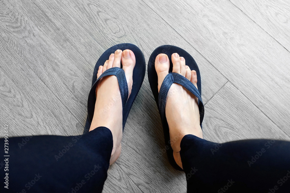 Black Flip Flops Isolated for Fashionable. Close Up of Legs Woman. Top  View. Woman Wear Black Footwear, Sandals on Wooden Background Stock Photo