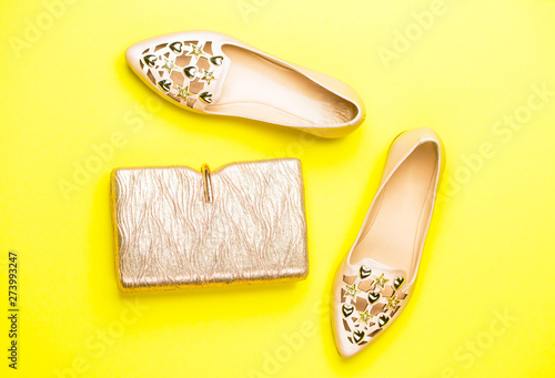 Fashion concept. Handbag, shoes isolated on yellow background, fashion. Top view. Pair of shoes and bag. Fashion and beauty concept. Women shoes and accessories, top view. Summer shoes.