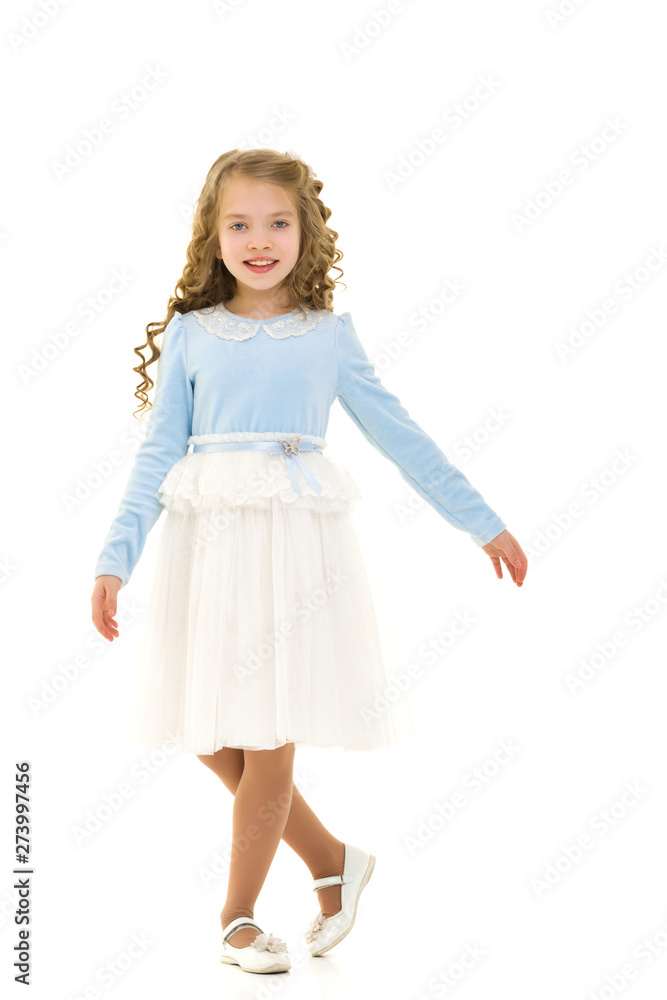 Fototapeta premium A little girl in a dress is spinning.
