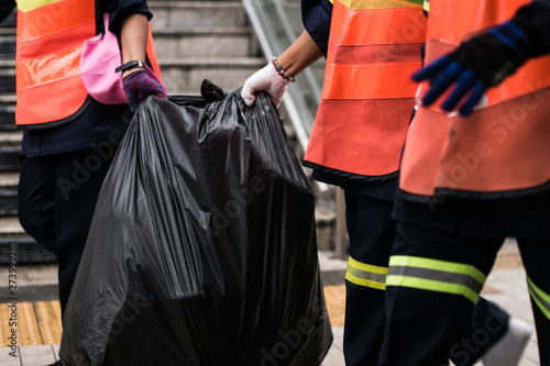 Officials, garbage are helping each other to transport garbage bags to the store.